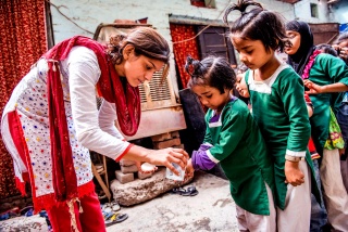 A volunteer washes children's hands in India