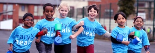 Young fundraisers in Ireland walk together with their arms linked.