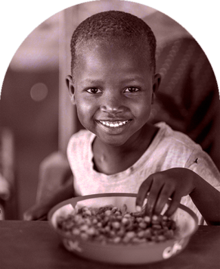 A child in Kenya sits down to eat at school