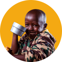 A young boy with a mug of food