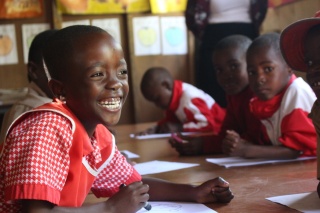 Image of a school girl smiling in class.