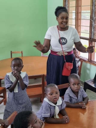 Image of a teacher and her students from a school feeding programme.