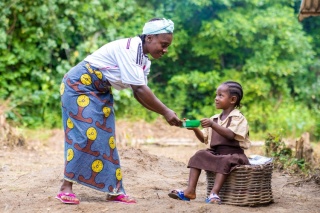 A volunteer hands food to a child